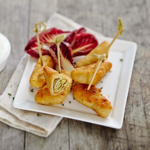 Assorted cooked Artichoke Quarters arranged in a square plate, seen from the front. 