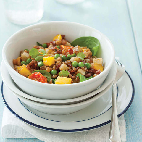 Extra Fine French Peas with tomatoes, basil and corn in a bowl, placed on a table, seen from the front.