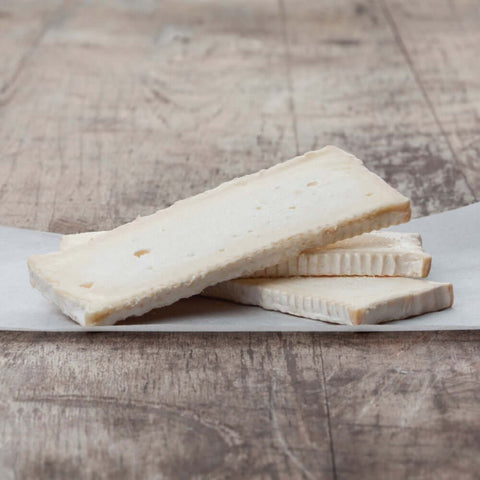 Assortment of Brie slices IQF 17.6oz arranged on marble, front view.