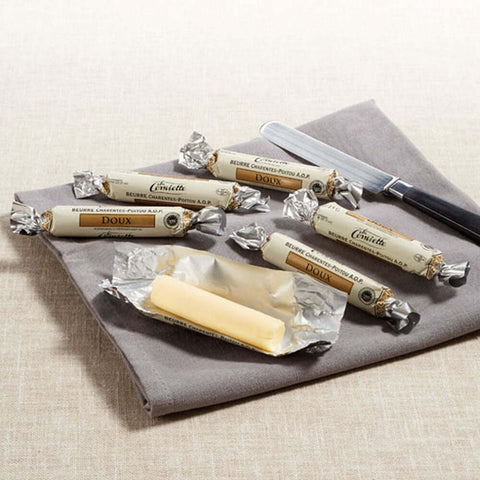 Assortment of 6 Conviette Mini French Butter Roll, Unsalted, placed on a napkin, with one of the butters open, front view.