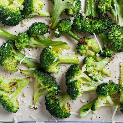 Assorted Broccoli Florets cooked with cheese, scattered on marble, seen from above. 