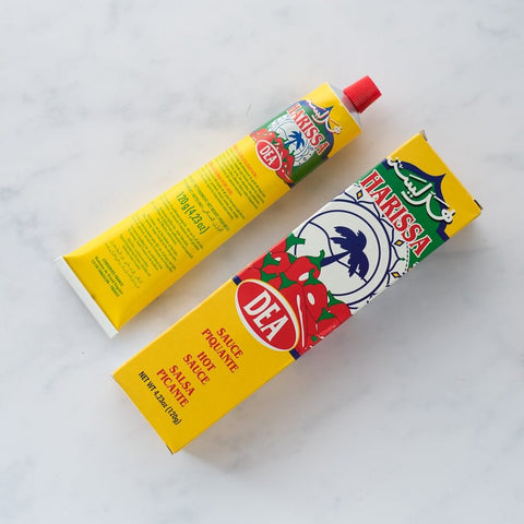 Tube of Harissa sauce of the Dea brand with its box of packing beside, seen above.