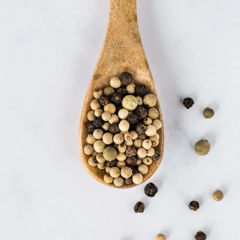 Wooden spoon containing 3 Peppers Blend, seen from above.