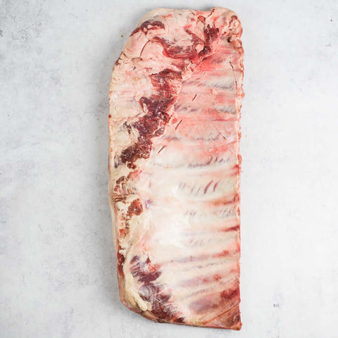 Ib??rico Pork Spare Ribs placed skin side down on marble, seen from above. 