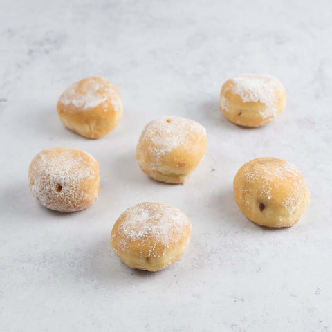 Assortment of 6 Mini Beignets Mixed Berries arranged on marble, front view. 