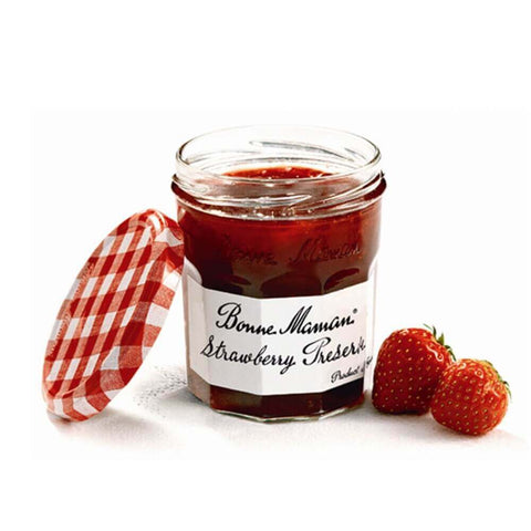 Glass jar of Strawberry Preserve open from the Bonne Maman brand, with two strawberry next to it, seen from the front.
