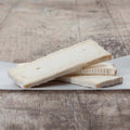 Assortment of Brie slices IQF 17.6oz arranged on marble, front view. 