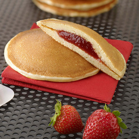 2 Strawberry-Filled Pancake, one cut in half, placed on a napkin, front view.