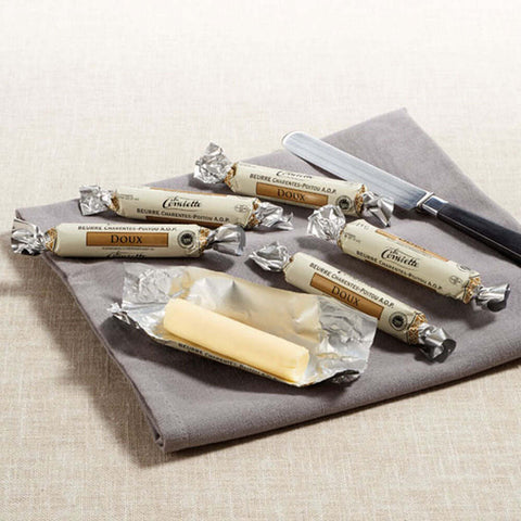 Assortment of 6 Conviette Mini French Butter Roll, Unsalted, placed on a napkin, with one of the butters open, front view. 