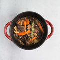 Beef Bourguignon cooked in a round dish on marble, seen from above.