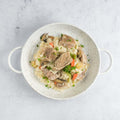 Blanquette de veau (Veal in a cream sauce) cooked in a round dish on marble, seen from above.