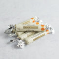Assortment of 5 wrapped Unsalted Butter Roll from La Conviette set on marble, front view.