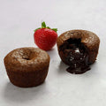 2 Lava Cake on marble, one open with a strawberry next to it, front view.