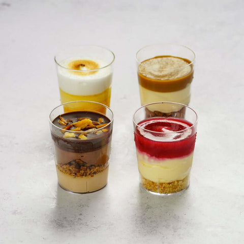 4 Assorted Dessert Shots placed on marble, front view.