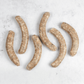 1 pack of 6 Chipolata Bistro Sausage set on marble, seen from above.