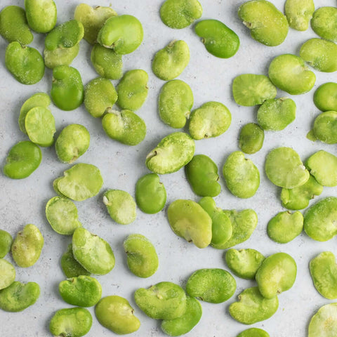 Assorted Peeled Fava Beans laid on marble, seen from above. 