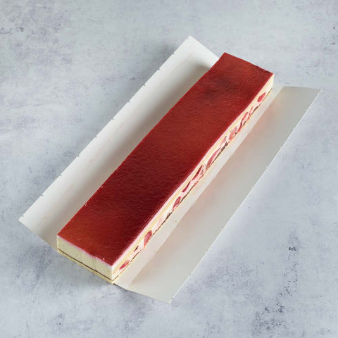 A large Strawberry Strip Cake in its cardboard packaging, seen from above. 