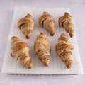 6 Vegan Chia Seed Croissants placed on a grid with baking paper, front view.