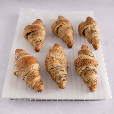 6 Vegan Chia Seed Croissants placed on a grid with baking paper, front view.