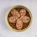 Morteau Sausage with Green Lentils in a round plate placed on marble, top view.