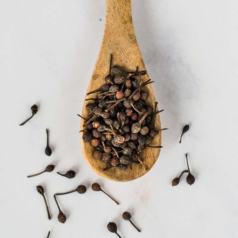 Wooden spoon containing Black Voatsiperifery Pepper, seen from above.