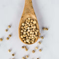 Wooden spoon containing White Penja Pepper, seen from above.