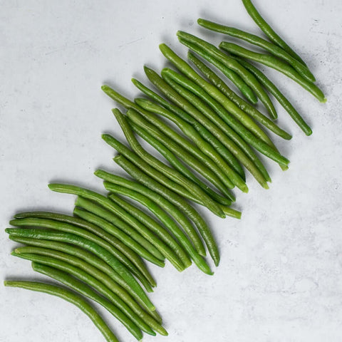 Extra Fine Green Beans scattered on marble, seen from above. 