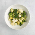 Cauliflower and Broccoli Veggie Mix arranged in a round dish on marble, seen from above.