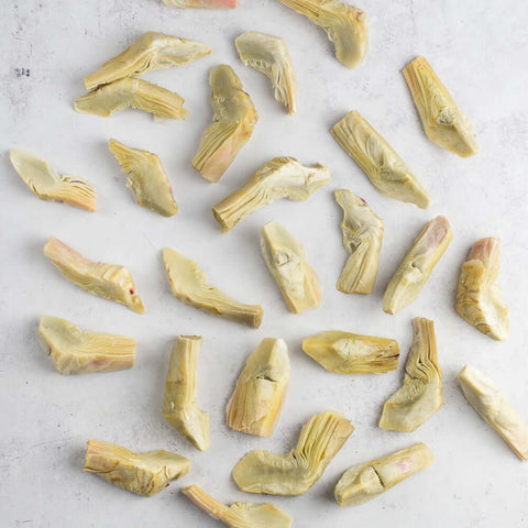 Assorted Artichoke Quarters laid on marble, seen from above. 