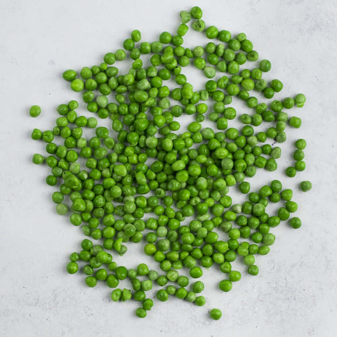 Extra Fine French Peas scattered on marble, seen from above.