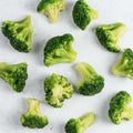 Assortment of Broccoli Florets scattered on marble, seen from above. 
