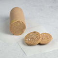 Duck Foie Gras Torchon cut into slices and placed on baking paper on marble, front view. 