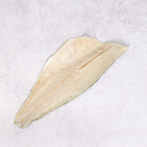 Piece of Estuary Branzino - European Seabass (Skin-On) on marble, seen from above. 