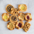 Assortment of 10 Assorted Mini Danish Pastries arranged on marble, seen from above.