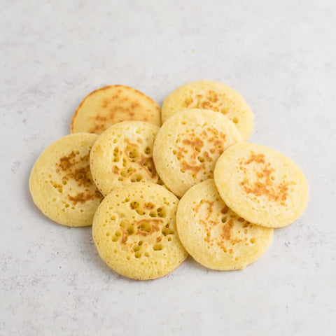 Assortment of 8 Mini Blinis arranged on marble, seen from above. 