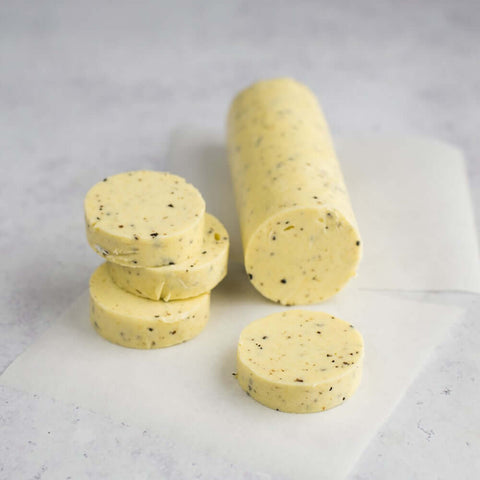 Truffle Butter Roll sliced and placed on a sheet of baking paper on marble, seen from above. 