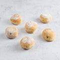 Assortment of 6 Mini Beignets Mixed Berries arranged on marble, front view. 