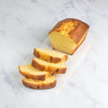 Sicilian Lemon Cake cut into several pieces and placed on a sheet of baking paper and placed on marble, seen from above.