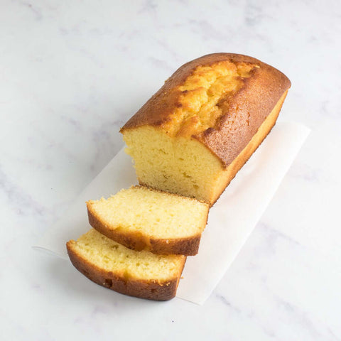 Sicilian Lemon Cake placed on a sheet of baking paper and placed on marble, seen from above.