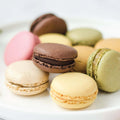 Assortments of 12 Classic French Macarons arranged on marble, front view.
