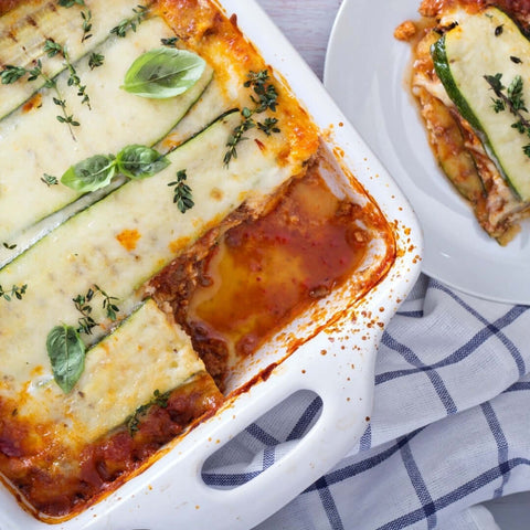 Assorted Grilled Zucchini Slices cooked in lasagna, arranged on a dish with some herbs, seen from above. 