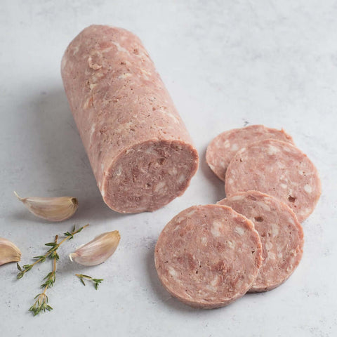 Garlic Sausage sliced and arranged on marble with some garlic, seen from above.