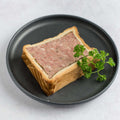 Country Pate en Croute arranged in a round plate, seen from above. 