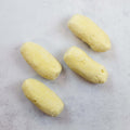 Assortment of French Quenelle Buns not yet baked, placed on marble, seen from above. 