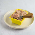 Rillettes du Mans in a plastic tray placed in a round plate, side view. 
