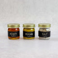 Mini Truffle Trio Gift Set with Truffle Honey, Truffle Mustard and Truffle Salt, placed on marble, front view.